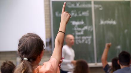 Eine Schülerin der fünften Klasse im bayrischen Aschaffenburg hebt im Unterricht den Finger. 