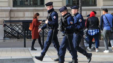 Polizeibeamte patrouillieren mit Gewehren vor dem Polizeipräsidium.