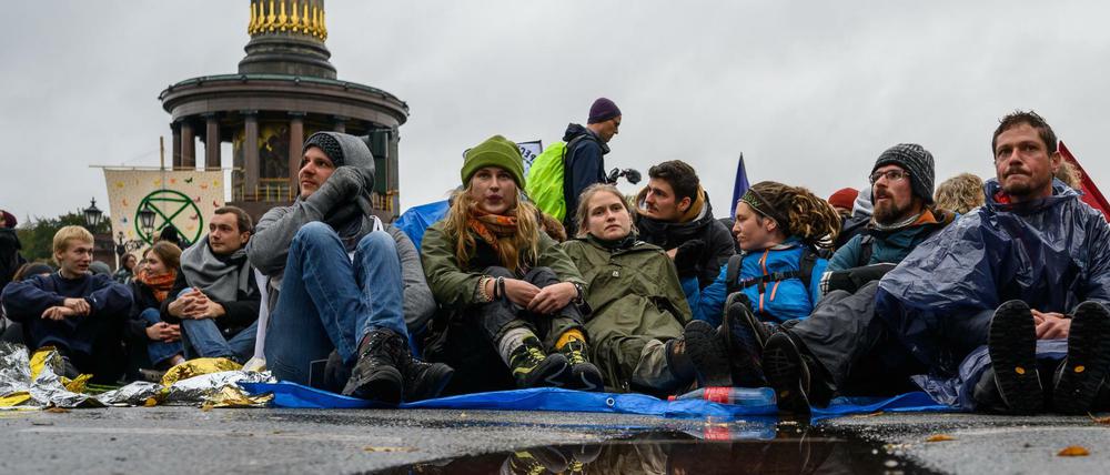 08.10.2019, Berlin: Aktivisten der Klimabewegung "Extinction Rebellion" haben während ihrer Aktionswoche "Berlin blockieren" die Zufahrten zum Großen Stern an der Siegessäule blockiert. 