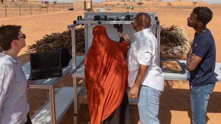 Vor den Pyramiden in Meroe, Sudan, installiert eine Museumsmitarbeiterin den Modultisch zur Fotodikumentation, den die KulturGutRetter mitgebracht haben.