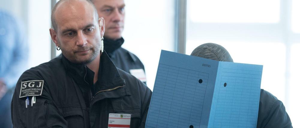 Ein Angeklagter wird am ersten Prozesstag in den Verhandlungssaal in Dresden geführt.