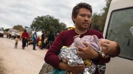 Ein afghanischer Mann kommt mit seinem Baby im Arm in Lesbos an.