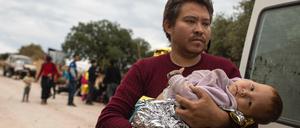 Ein afghanischer Mann kommt mit seinem Baby im Arm in Lesbos an.