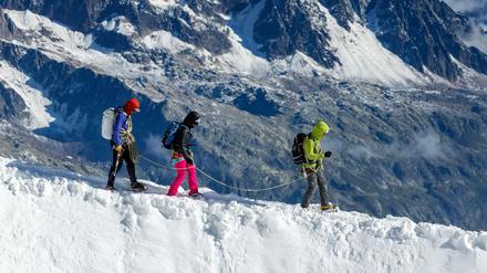 Drei Bergsteiger auf dem schneebedeckten Kamm des Mont Blanc. 