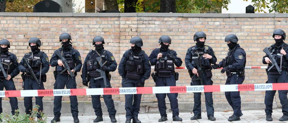 Polizisten vor der Mauer des jüdischen Friedhofs in Halle.