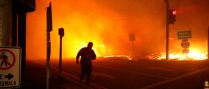 Ein Mann beobachtet in Kalifornien ein Feuer bei einer Auffahrt zu einer Autobahn.