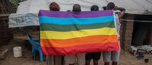 Geflüchtete queere Menschen aus Uganda posieren in einem Flüchtlingslager im kenianischen Kakuma mit einer Regenbogenflagge (Archivbild).