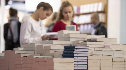 Besucherinnen blättern auf der Frankfurter Buchmesse durch Neuerscheinungen.