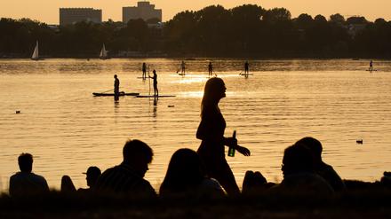 Jugendliche an der Alster in der Abendsonne.