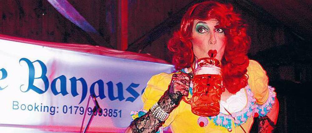 Drag Queen Mataina Ah-wie-süss trinkt Maß mit Strohhalm. 