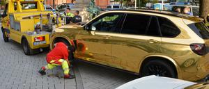 Ein goldener BMW SUV wird nahe der Düsseldorfer Königsallee abgeschleppt.