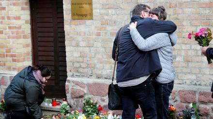 Am Tag nach dem Anschlag legen Menschen Blumen an der Synagoge nieder, trauern gemeinsam.