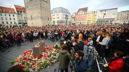 Auf dem Marktplatz in Halle legen Menschen als Zeichen der Trauer Blumen ab.