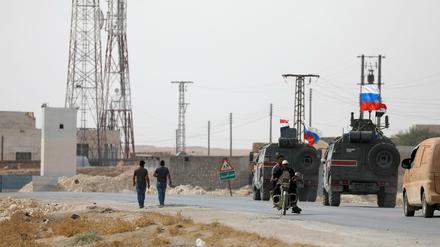 Russische und syrische Flaggen auf Militärfahrzeugen in der Nähe von Manbidsch.