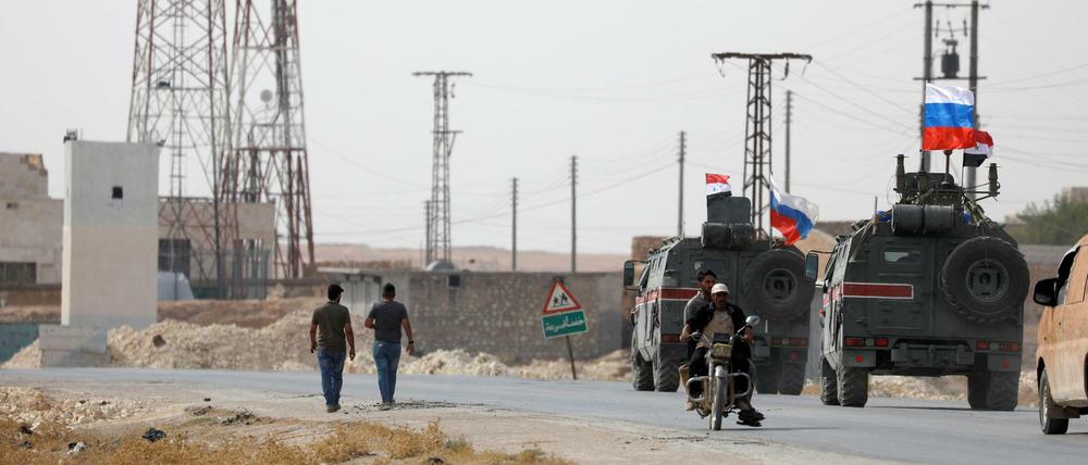 Russische und syrische Flaggen auf Militärfahrzeugen in der Nähe von Manbidsch.
