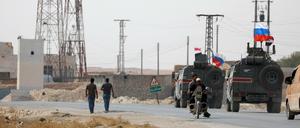 Russische und syrische Flaggen auf Militärfahrzeugen in der Nähe von Manbidsch.