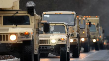 US-Militärfahrzeuge fahren in Brandenburg auf der Straße eines Truppenübungsplatzes.