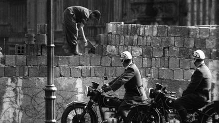  Arbeiter erhöhen die Sektorensperre an der Bernauer Straße in Berlin.