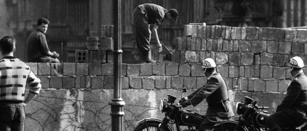 Arbeiter erhöhen die Sektorensperre an der Bernauer Straße in Berlin.