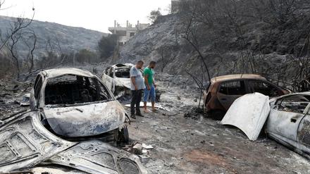 Anwohner begutachten ausgebrannte Fahrzeuge im Ort Damour südlich von Beirut. Ein Waldbrand war durch den Ort gezogen.