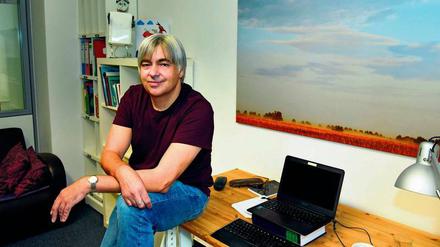 Salah Naoura besitzt kein Handy und schreibt immer an dem Schreibtisch, der gerade frei ist. Das Bild an der Wand fotografierte Autorin Katja Ludwig im Oderbruch. 