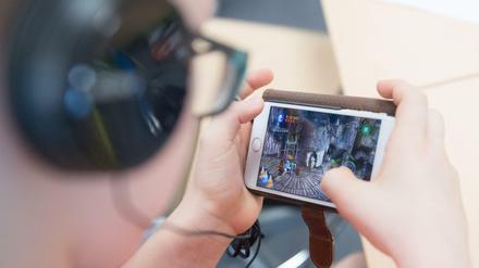 Ein Schüler spiel auf einem Smartphone.