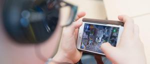 Ein Schüler spiel auf einem Smartphone.
