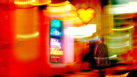 Ein potentieller Kunde passiert das erleuchtete Fenster eines Sexshops in Berlin.