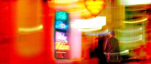 Ein potentieller Kunde passiert das erleuchtete Fenster eines Sexshops in Berlin.