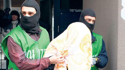 Polizisten führen bei einer Razzia gegen Islamisten einen Verdächtigen ab.