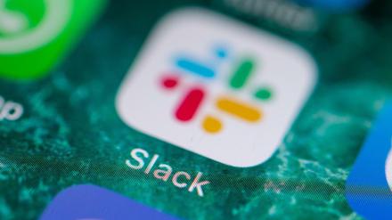 Auf dem Bildschirm eines iPhones wird die Messenger-App Slack angezeigt. 