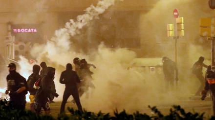 Katalanische Demonstranten werfen einen Tränengas-Behälter zurück auf die Polizei.