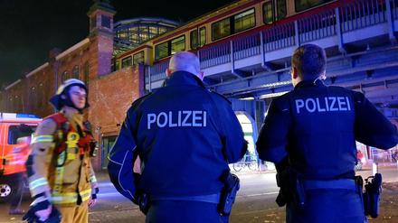 Polizisten stehen Samstagabend am Bahnhof Bellevue und unterhalten sich mit einem Feuerwehrmann.