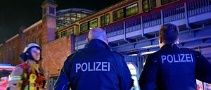 Polizisten stehen Samstagabend am Bahnhof Bellevue und unterhalten sich mit einem Feuerwehrmann.