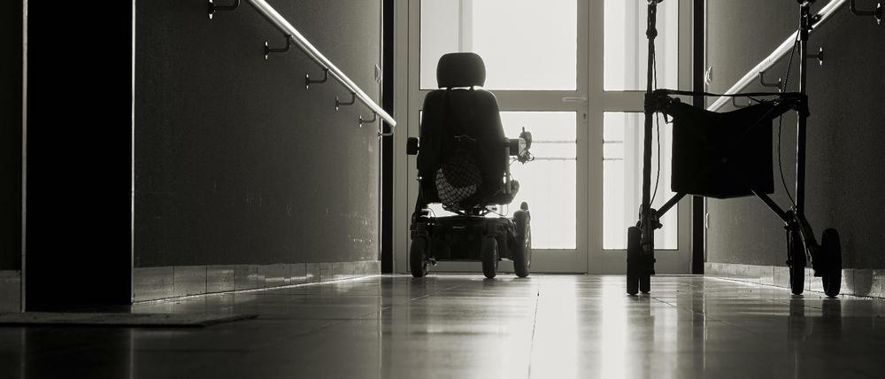 Einsamer Flur mit Rollator und einem Rollstuhl in einem Seniorenheim.