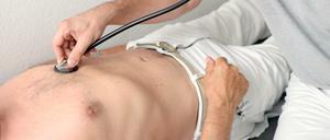 Ein Hausarzt untersucht einen Patienten mit einem Stethoskop.