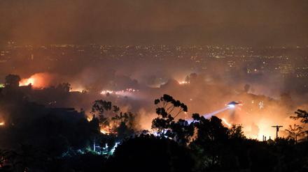 Ein Hubschrauber fliegt über einem Wohngebiet, das vom sogenannten Getty-Feuer betroffen ist.