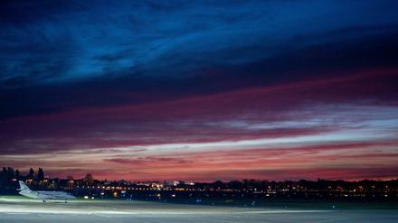 Ein Flugzeug steht im Mondlicht kurz vor dem Sonnenaufgang auf dem Flughafen Berlin Tegel.