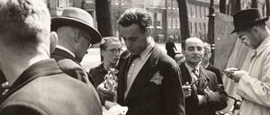 Mitarbeiter des Bureau Joodse Zaken (Amt für Jüdische Angelegenheiten) der Amsterdamer Polizei überprüfen die Personalausweise jüdischer Händler auf dem Briefmarkenmarkt am Nieuwezijds Voorburgwal in Amsterdam.Sommer 1942.