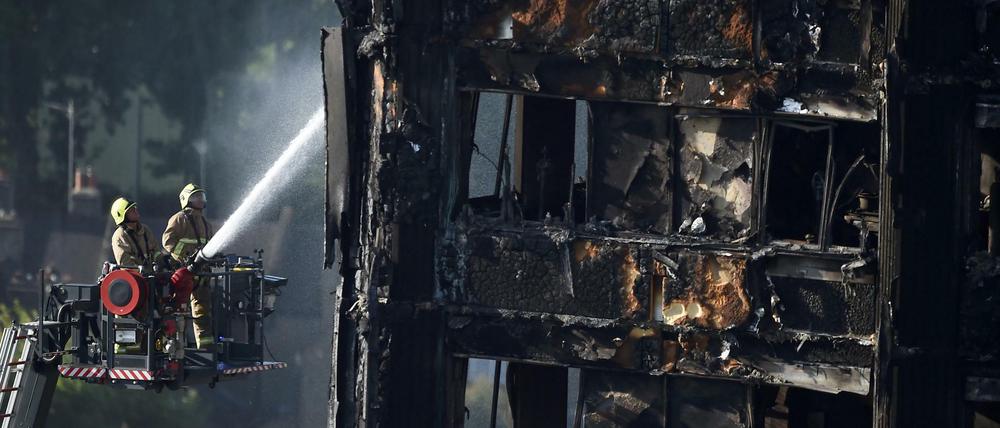 Feuerwehrleute besprühen den zerstörten Wohnblock im Westen Londons am 16. Juni 2017 mit Wasser.