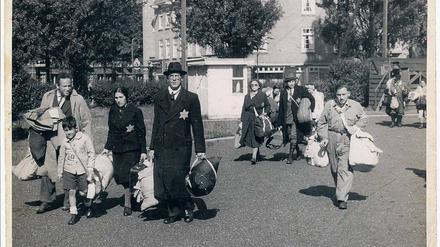 Vor aller Augen. Am Morgen des 20. Juni 1943, einem Sonntag, finden in Amsterdam große Razzien statt. Ganze Stadtviertel werden abgeriegelt und Juden werden aufgefordert, sich zu Sammelplätzen zu begeben. Viele Juden haben diese Aktion erwartet; ihr Gepäck steht schon an der Tür bereit. Familien kommen hier mit schwerem Gepäck zum Sportpark auf dem Olympiaplein, dem Sammelplatz im Süden von Amsterdam.Foto: Herman Heukels NIOD