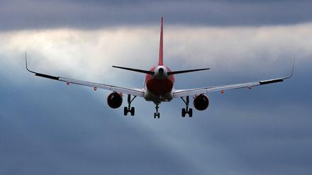 Ein Flugzeug der Airline EasyJet landet vor düsterem Himmel in Berlin-Schönefeld.