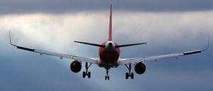 Ein Flugzeug der Airline EasyJet landet vor düsterem Himmel in Berlin-Schönefeld.