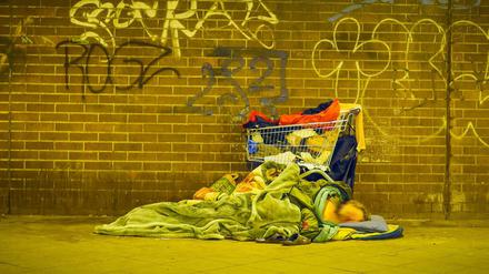 Eine obdachlose Person schläft am Bahnhof Zoologischer Garten.