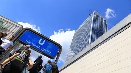 Passanten am U-Bahnhof und dem Hochhaus vom Hotel Park-Inn auf dem Alexanderplatz in Berlin-Mitte.