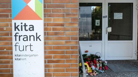 Blumen und Kerzen sind am Eingang der Kindertagesstätte abgelegt.