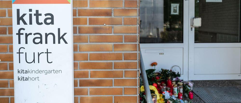 Blumen und Kerzen sind am Eingang der Kindertagesstätte abgelegt.