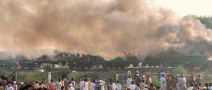 Menschen stehen vor dem brennenden Zug.