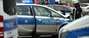 Ein Feuerwehrmann steht nach einem Unfall an einem beschädigten Polizeiauto.