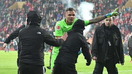 Vermummte Union-Hooligans stürmen das Spielfeld, doch Union-Torwart Rafal Gikiewicz stellt sich ihnen entgegen.